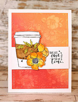 Floral travel mug on a bright orange card, 'take life one sip at a time'.