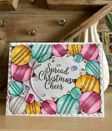White card with the ornament border colored in pastel pinks, teals and golds with scattered sequins, and a circle reading Spread Christmas Cheer.