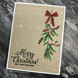 Handmade card featuring the strand of jingle bells and a sprig of holly berries, matted on kraft, stamped with 'Holiday hugs & mistletoe kisses'.