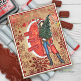 Red-toned card with Ember Girl over stamped snowflakes and script, ink pads and red rubber alongside.