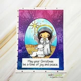 The angel and lamb framed in an oval on a purple sunburst card, captioned 'May your Christmas be a time of joy and peace.'