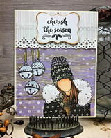 Card of the cozy winter girl with ornaments and 'cherish the season.'
