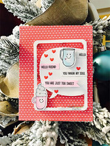 Card with the smiling mug and cupcake colored in soft pink and blue on a white speech bubble panel, red hearts around them and banner labels reading 'HELLO', 'HELLO FRIEND', 'YOU WARM MY SOUL' and 'YOU ARE JUST TOO SWEET', matted in coral polka dot.