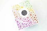 The star background blended in a rainbow ombre of pink, orange and green on a card.