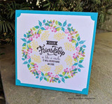 Aqua card with yellow and green blossom wreath around the friendship circle quote