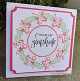 Pink-framed wreath of red berries and greenery around you're my sunshine