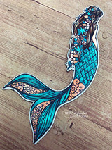 Die-cut mermaid colored in teal, copper and blue scales, shown on weathered wood.