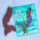 Aqua cloud card with the mermaid in purple and blue among seaweed and a 'She is brave and full of love' sentiment, shown with the red rubber mermaid stamp.