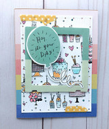 Card with the cake background stamped in black over white and hand colored in soft pastels, layered on rainbow stripes, with a mint die cut balloon and frame on top.