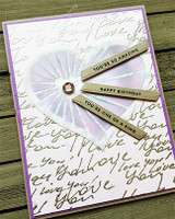 Card using the love-script background behind a folded paper fan medallion, with sample sentiments 'You're so amazing' and 'Happy Birthday.'