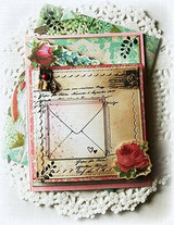 Vintage-style card with the distressed envelope on script paper trimmed with lace, a rose and greenery.
