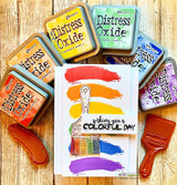 Card of the paintbrush over a rainbow of Distress Oxide swatches with "wishing you a colorful day."
