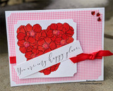 Pink gingham card with the floral heart colored in deep reds and corals, a white banner reading You are my happy place and a red grosgrain ribbon.