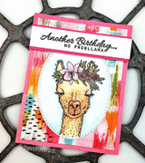 The party llama with a flower crown fussy-cut onto a mixed-media pink card in an oval frame.