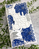 Slimline card with navy and silver blooms down both sides and a white die cut phrase you are loved layered in the center, photographed with greenery.