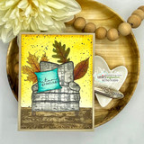 Autumn card of the burlap background behind a stack of books, leaves and 'autumn greetings.'