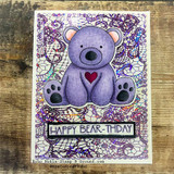 Handmade card featuring the delicate all-over lace pattern filling an A2 background, in purple over a teddy bear, stamped with 'Happy Bear-thday'.