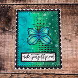 Card with a deep teal and green inked panel inside a black scalloped frame, one blue butterfly, sentiment 'KEEP GOING, make yourself proud'.