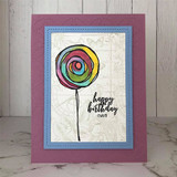A single rainbow lollipop on a soft mauve framed card, reading 'happy birthday (YAY!).'