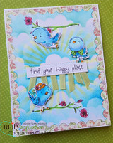 Card with the birdies colored bright blue on a floral branch over a painted sky, 'find your happy place.'