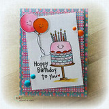 Grinning cake and a smiley balloon, 'Happy Birthday to you,' on a bright plaid card.