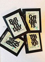 Oversized bold block-letter greeting words hand-stamped on a card and lettered "Birthday."