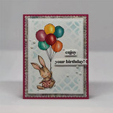 Gray stenciled panel on a magenta base with pearls: the bunny holds jewel-colored balloons beside “enjoy your birthday!”