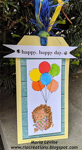 Handmade banner tag with blue tassel: the hedgehog holds primary-colored balloons under a “happy, happy day.” flag.