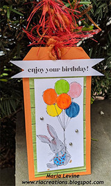 Orange gift-tag card with red fibers: the bunny holds primary balloons under an “enjoy your birthday!” banner.