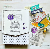Card with 'kindness changes everything' and postage marks on a black-dot panel with tags.