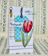 Tall card with a red tulip on a blue plaid tag, stamped 'be unstoppable.'
