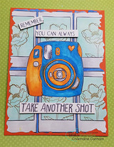 Card with an orange-and-blue instant camera on striped paper, stamped 'Remember, you can always take another shot.'