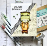 Card on book-page paper with black and white stripes; Frank wears an orange suit beside 'i love you just the way you are' and green enamel dots.