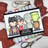 Card with a lineup of colored Halloween characters — vampire, devil, mummy and monster — above “have a killer HALLOWEEN,” with red rubber stamps alongside.