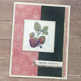 Card with stamped strawberries on a white square over pink floral and black panels with gold glitter trim and the sentiment 'berry thankful'