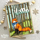 Card with a red fox in a blue scarf sitting before the stamped trees under a die-cut 'Hello.'