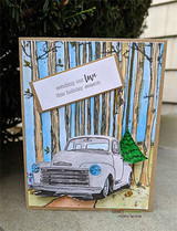 Card of a gray truck among birch trees in a wintry forest scene.