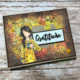 Card using the leaf border in glowing autumn hues around a figure, with a 'Gratitude' banner across the center.