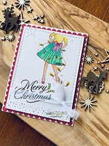 Card with the girl in a teal and pink dress on a white panel over deep pink paper, staged with metal snowflake dies, and the Merry Christmas script.