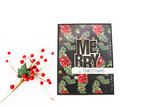 Small dark floral card stamped with the bold 'MERRY CHRISTMAS' block sentiment.