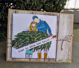 Card with the couple hauling the tree on a wood-look panel, 'time to deck the halls'