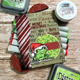 Santa-hat frog on a mixed-media 'Merry Christmas' script background.