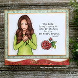 Framed card with the girl in a green top holding a cross and a red rose with the scripture.