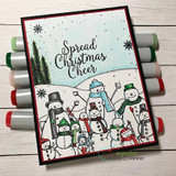 Card matted in deep red with green pine trees and the snowmen coloured in soft greys and blues, photographed on a row of alcohol markers.