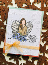 The angel embossed on a soft textured card tied with sheer orange ribbon.