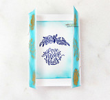 Soft teal card with 'Love never fails' stamped in navy on white.