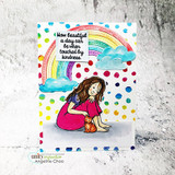The girl in a pink dress with a ginger cat under a rainbow-and-clouds polka-dot card, captioned "How beautiful a day can be when touched by kindness."