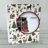 Christmas-paper card with the girl at a window inside a circle frame, 'I Believe.'
