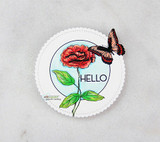 A circle cut card with a red rose and a coral butterfly colored on a pale blue sky, with die cut HELLO lettering across the middle.