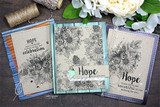Three coordinating cards in kraft, teal and lavender, each stamped with the uncolored floral swag and a 'Hope' sentiment.